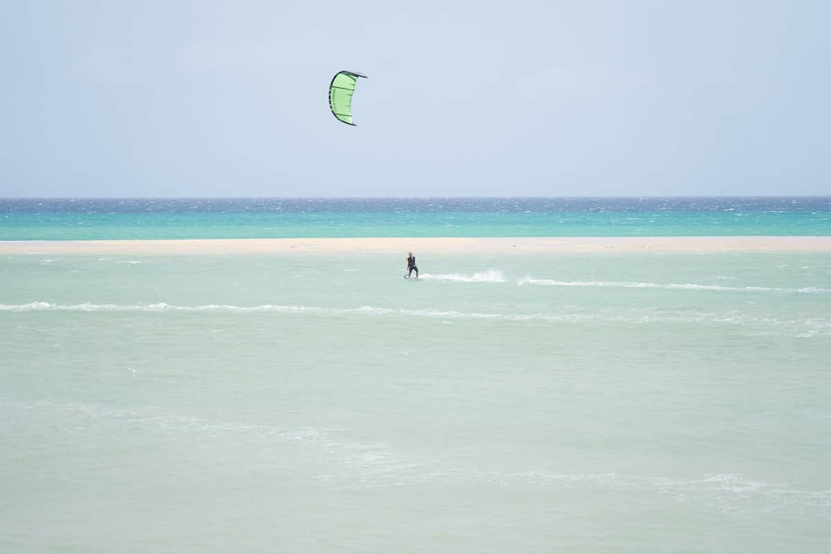 Wide golden sand beach with shallow turquoise lagoon at low tide at Playa de Sotavento, Fuerteventura