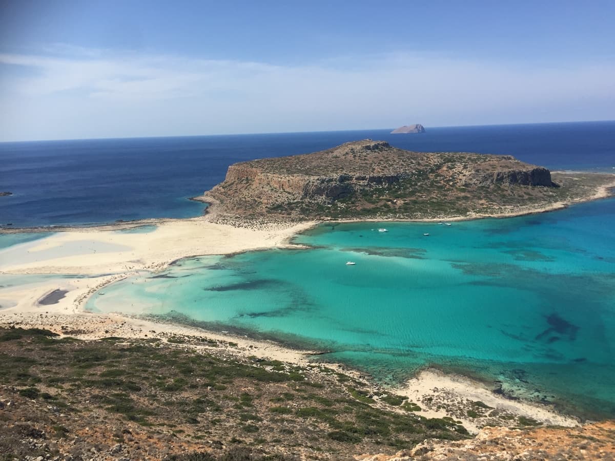 Pink-tinted sand and shallow turquoise lagoon at Elafonissi Beach in Crete, Greece