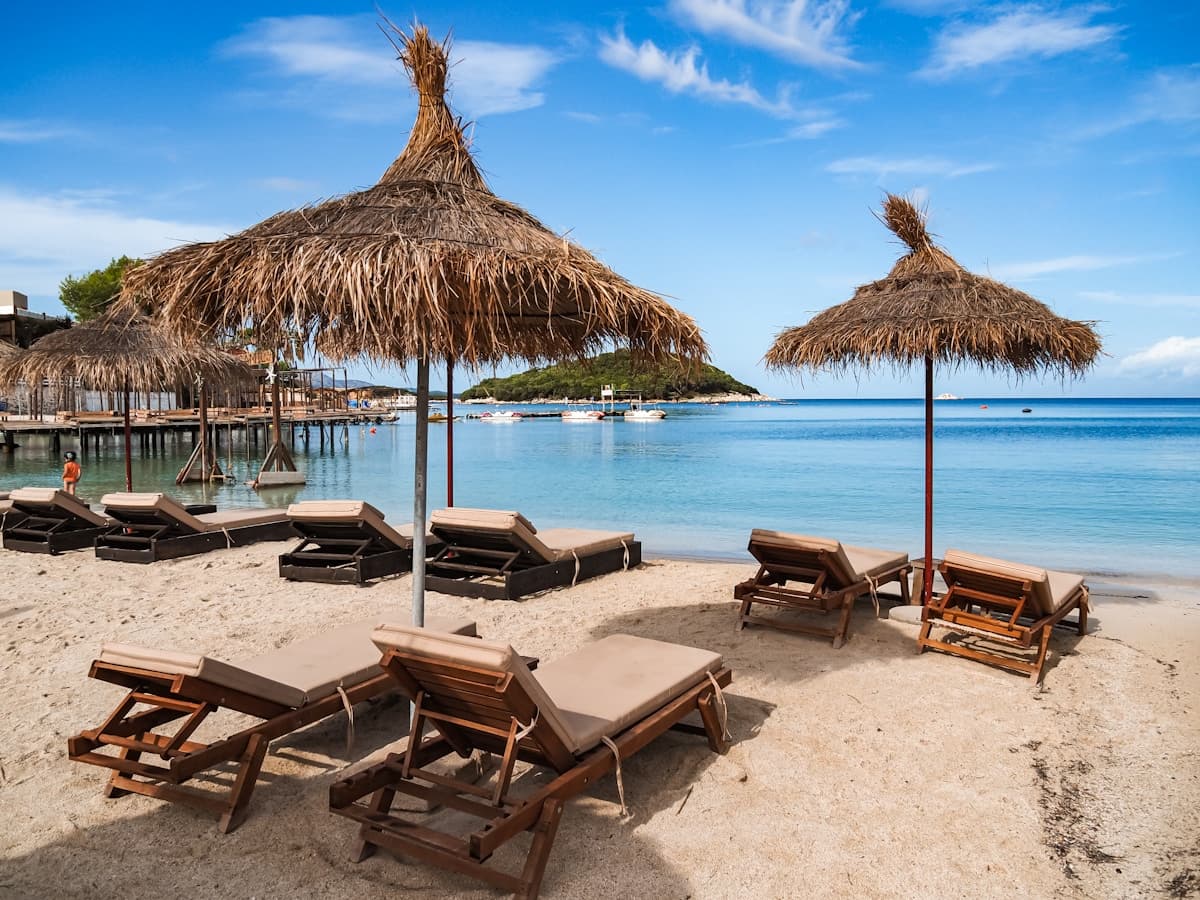 Turquoise waters and white sand at Ksamil Beach in southern Albania with small islands visible offshore