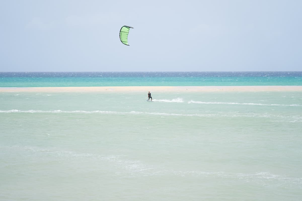 Wide golden sand beach with shallow turquoise lagoon at low tide at Playa de Sotavento, Fuerteventura