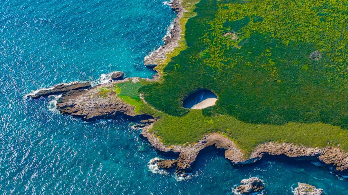 Turquoise water inside the collapsed volcanic crater of Playa del Amor on the Marietas Islands with sandy beach visible through the open ceiling