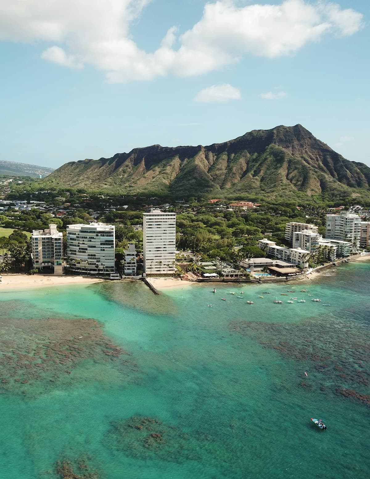 Waikiki Beach in Honolulu with Diamond Head crater in the background and high-rise hotels lining the shore