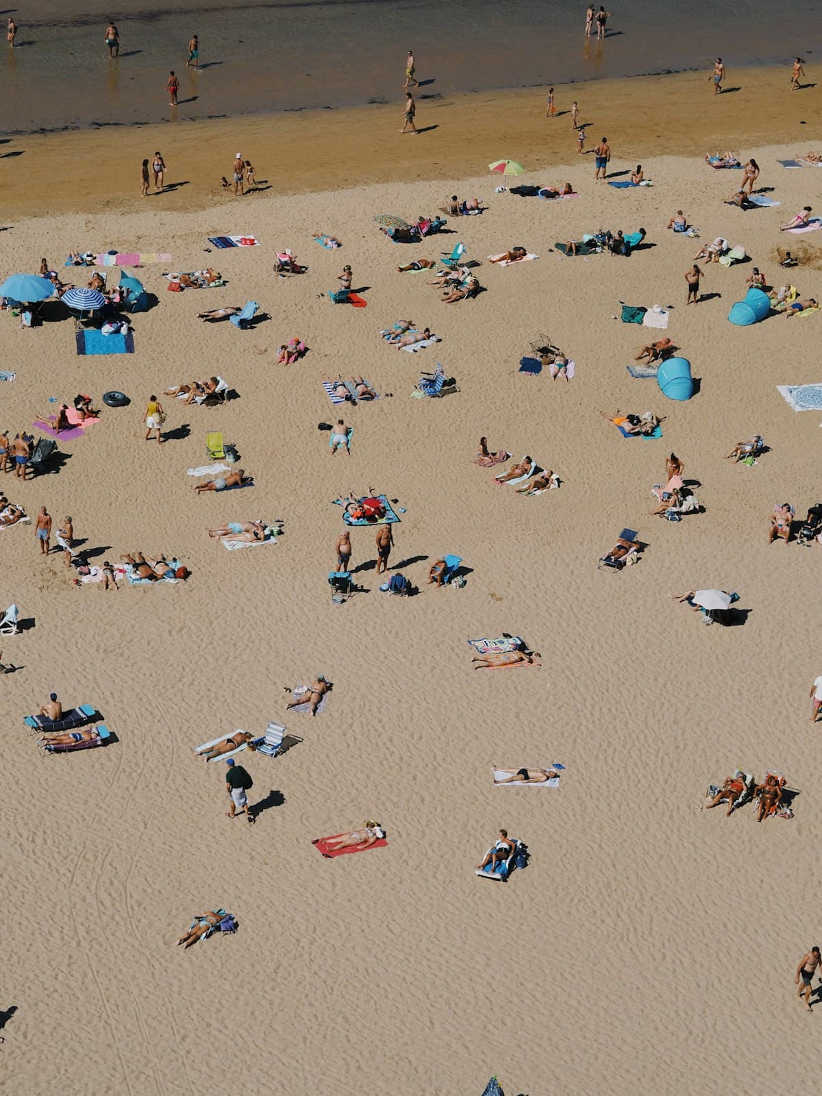 Crowded beach packed with people and umbrellas on a summer day