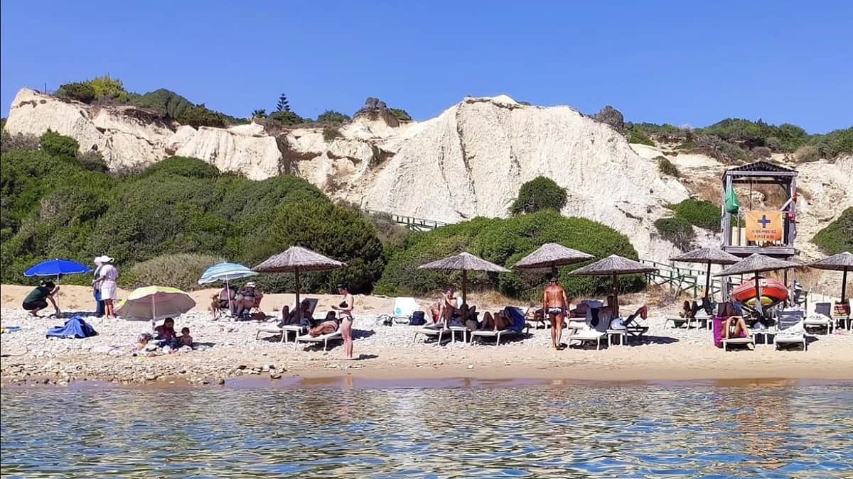 Gerakas Beach Zakynthos with the red clay cliffs behind the golden sand and the marine park protected bay