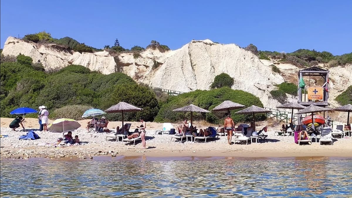 Gerakas Beach Zakynthos with the red clay cliffs behind the golden sand and the marine park protected bay
