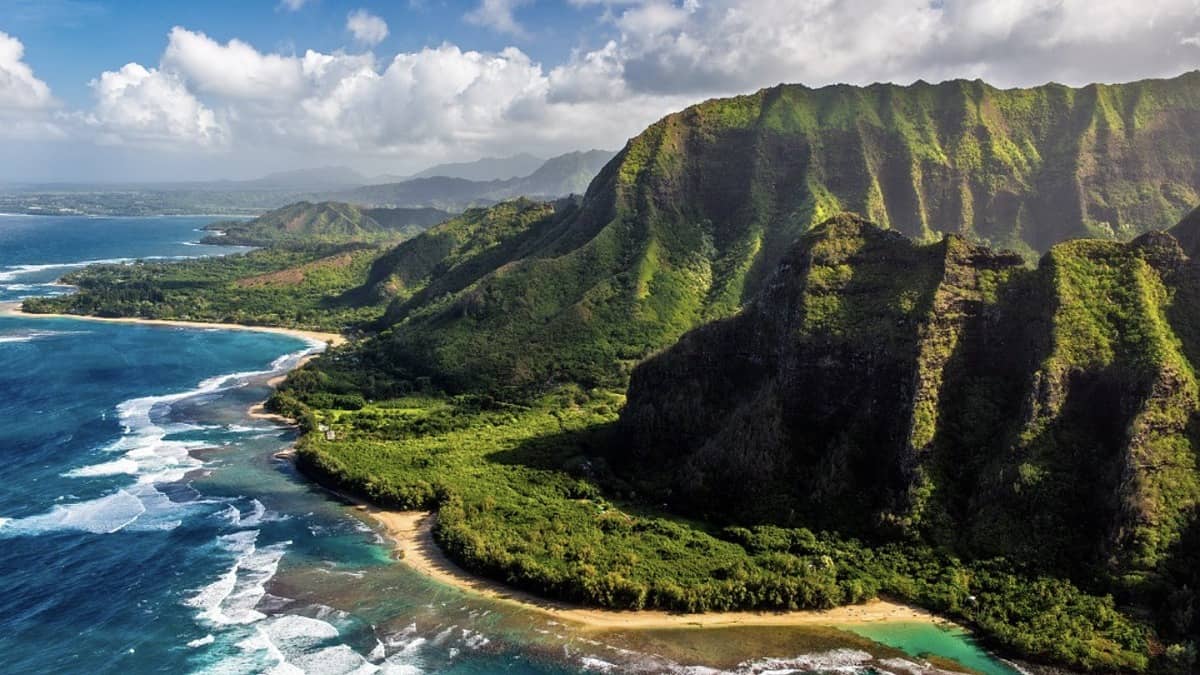 Ke'e Beach lagoon at the end of Kuhio Highway with the Na Pali cliffs rising behind the sand
