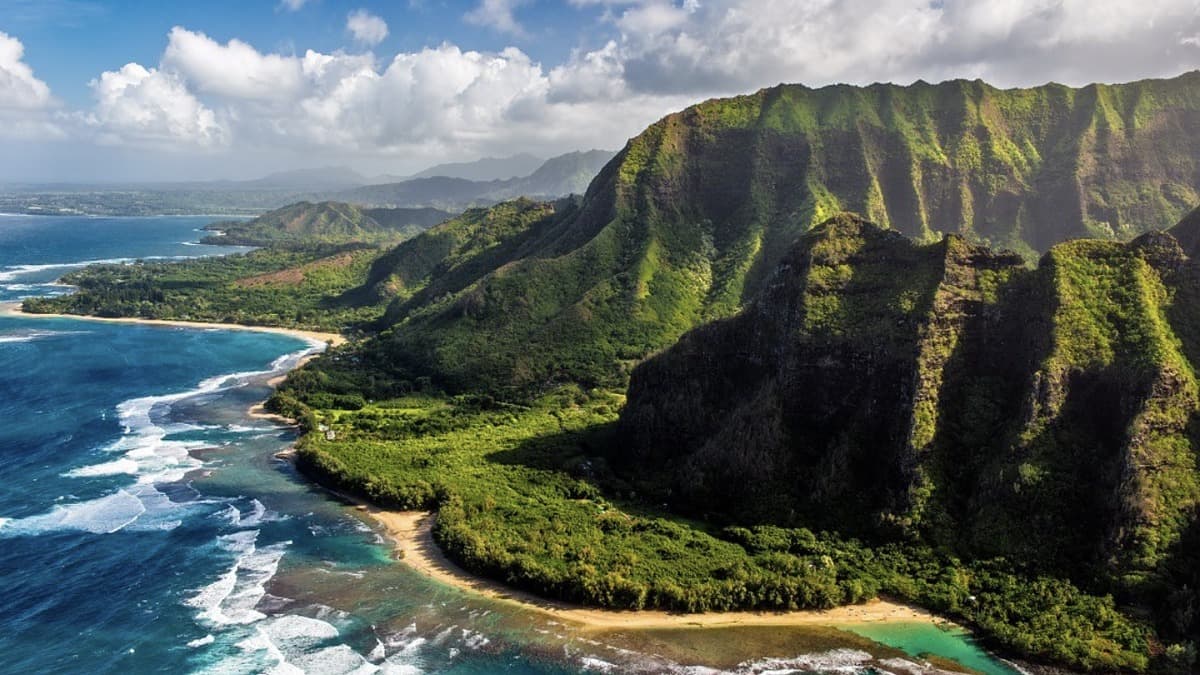 Ke'e Beach lagoon at the end of Kuhio Highway with the Na Pali cliffs rising behind the sand