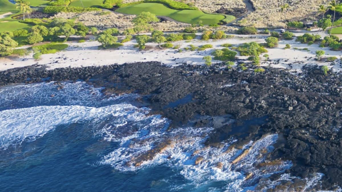 Kohanaiki Beach Park (Pine Trees) on the Big Island Kona coast with surf breaking on the lava-rock shore
