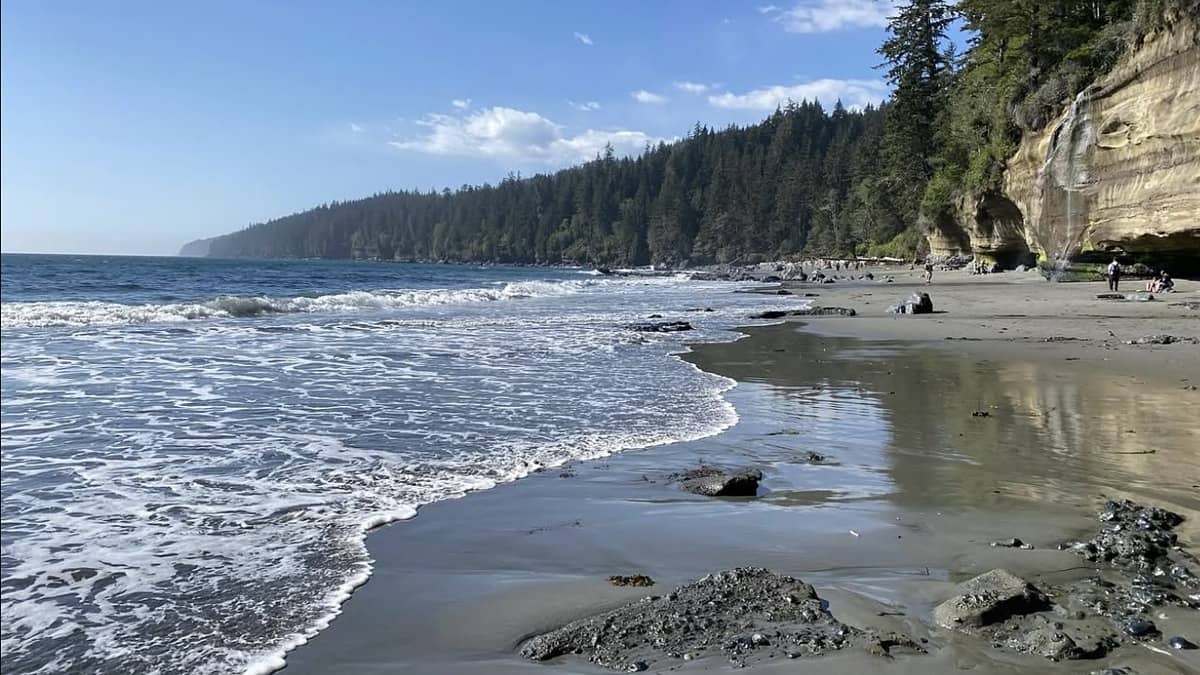 Mystic Beach Vancouver Island BC with the waterfall dropping onto the sand and the sea cave at the south end