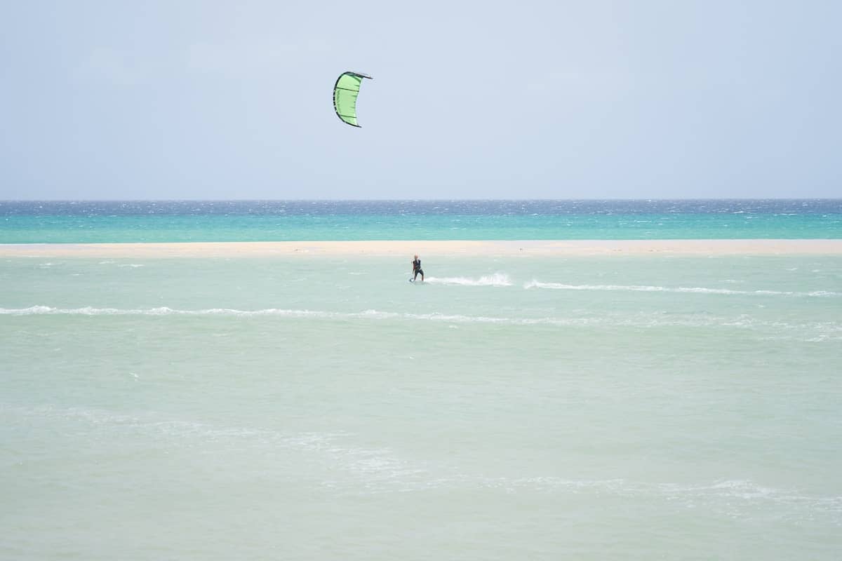 Wide golden sand beach with shallow turquoise lagoon at low tide at Playa de Sotavento, Fuerteventura