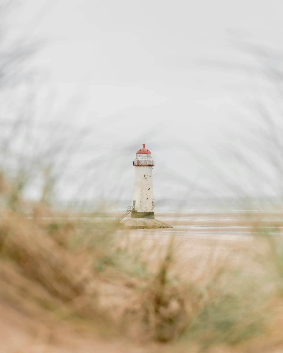 The white Point of Ayr Lighthouse standing on the wide sandy shore at Talacre Beach in North Wales