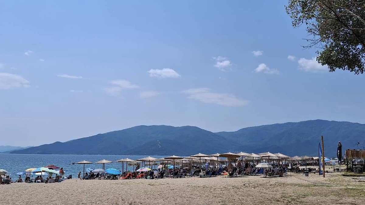 Vrasna Beach Greece with golden sand, calm Aegean water, and umbrellas at Nea Vrasna