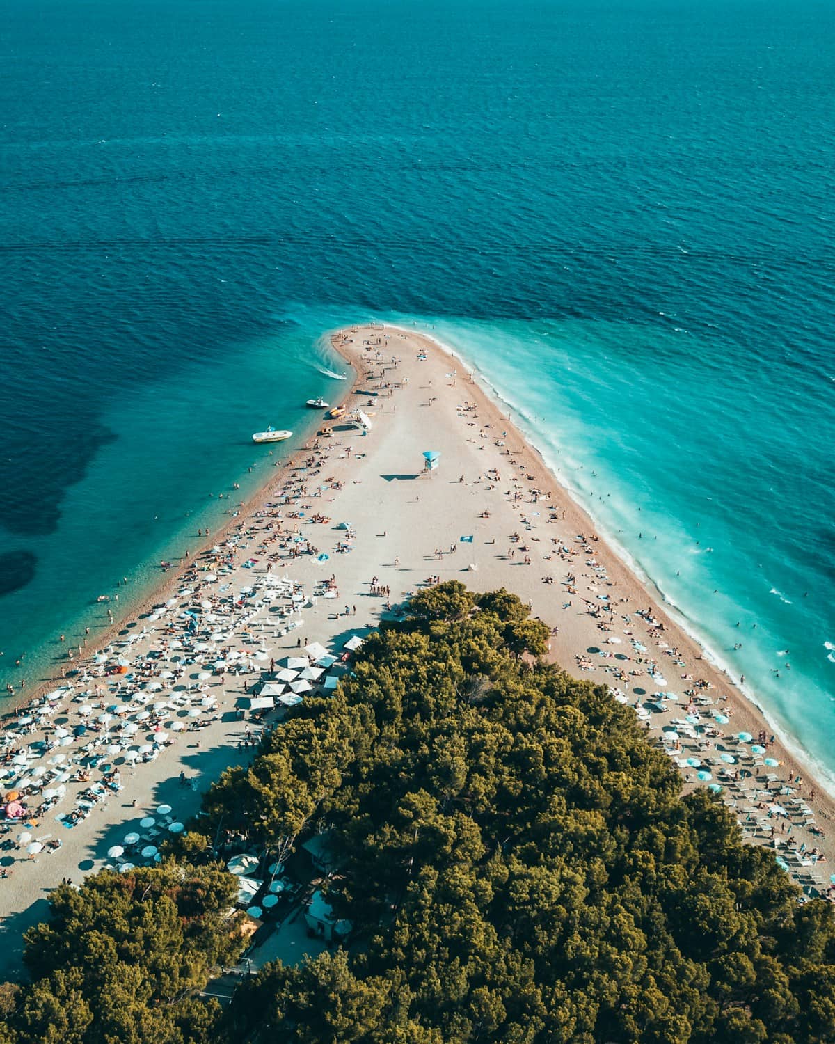 Aerial view of Zlatni Rat Golden Horn beach in Bol Croatia showing its distinctive triangular pebble spit extending into bright blue Adriatic water