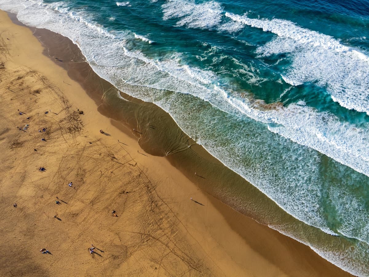Golden sand beach on Fuerteventura with turquoise water and volcanic hills in the background