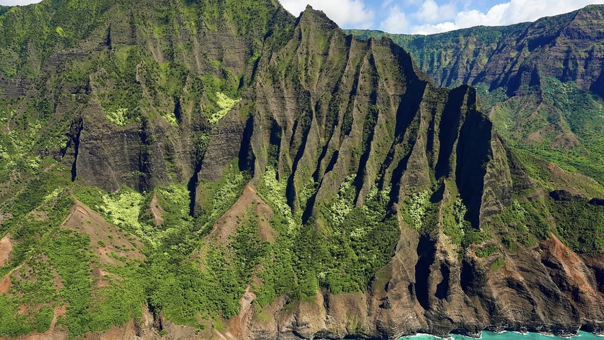 Hanalei Bay's crescent of sand with green mountains rising behind it, Kauai