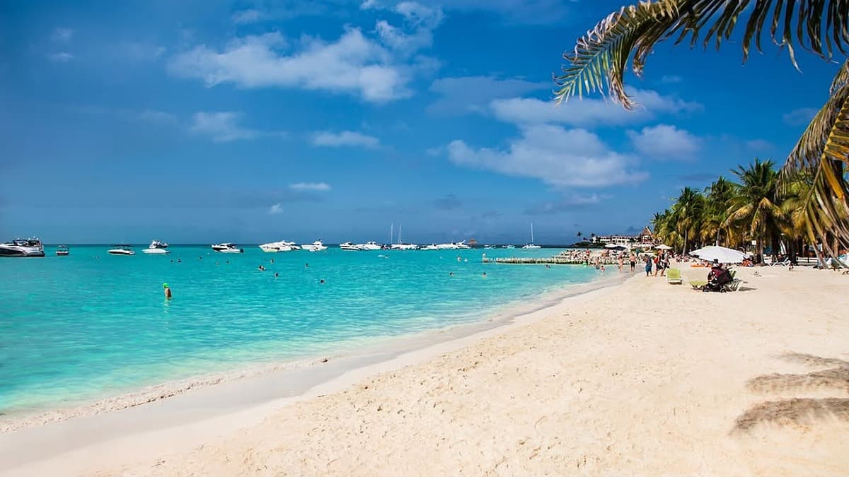 Turquoise Caribbean water at Playa Norte Isla Mujeres with white sand and palm trees, one of the best beaches in Mexico