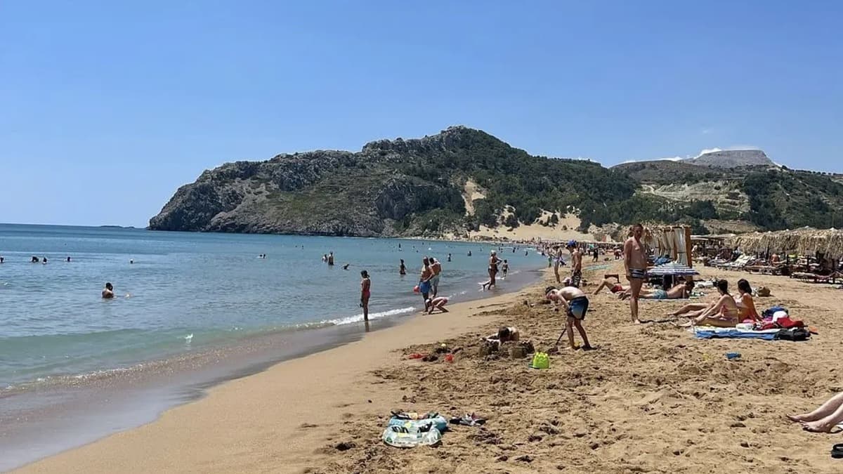 Tsampika Beach on the east coast of Rhodes, the long golden sand bay with Tsambika mountain rising behind and turquoise Aegean water