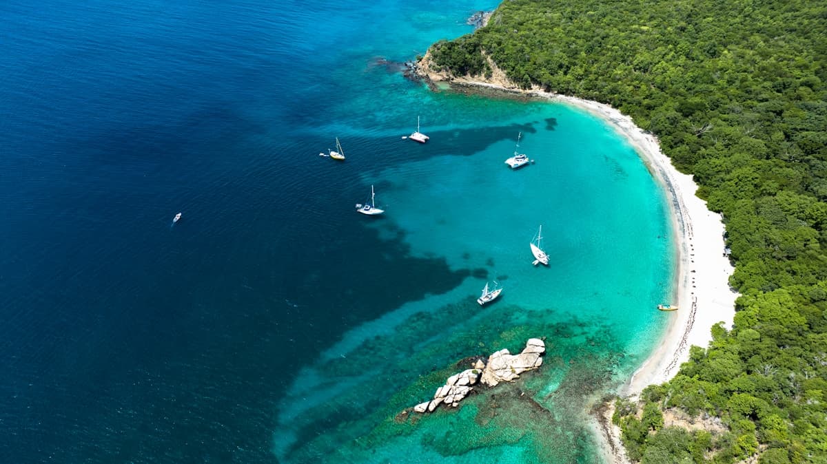 Hidden cove beach surrounded by cliffs with crystal clear water