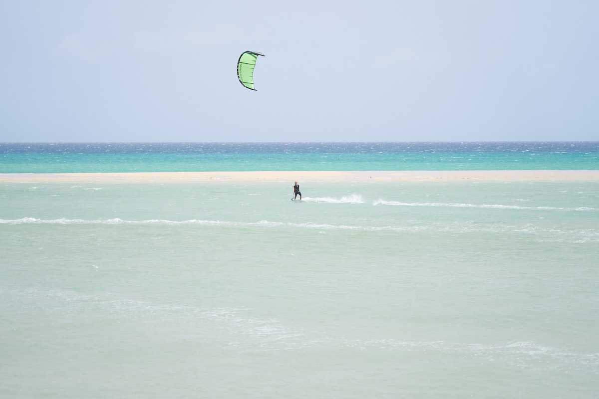 Wide sandy beach at Playa de Sotavento with kitesurfers in turquoise water