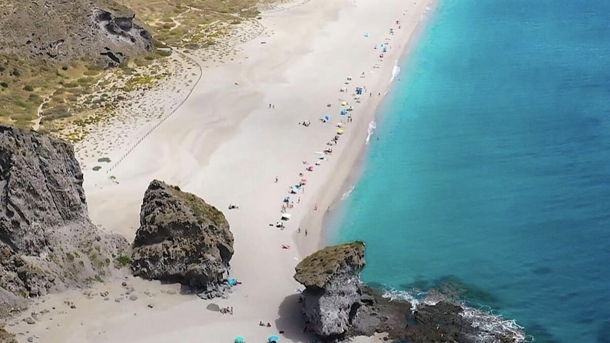 Playa de los Muertos in Almeria, a wild pale pebble cove below tall cliffs with clear green water