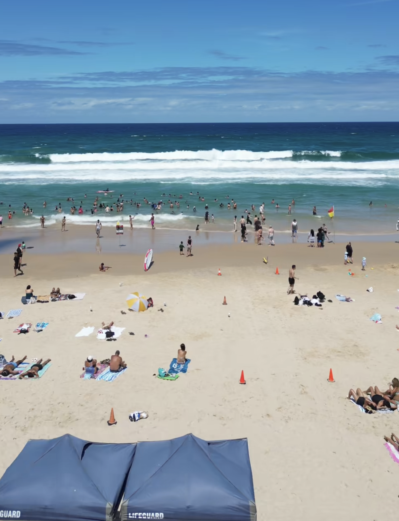 Calm turquoise water at Tallebudgera Creek with families on the sandy shore