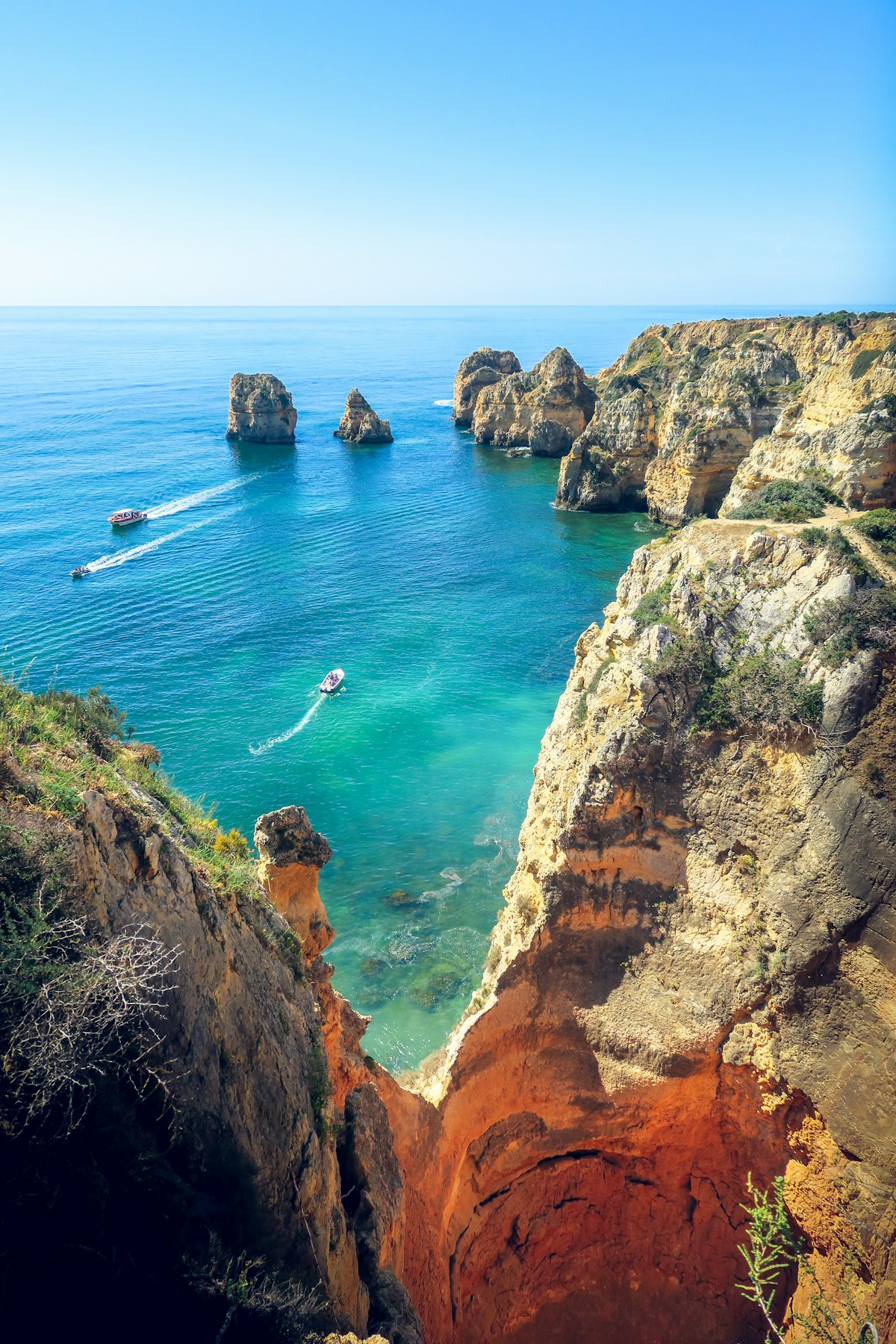 Clear turquoise cove surrounded by golden sandstone at Praia do Camilo Lagos