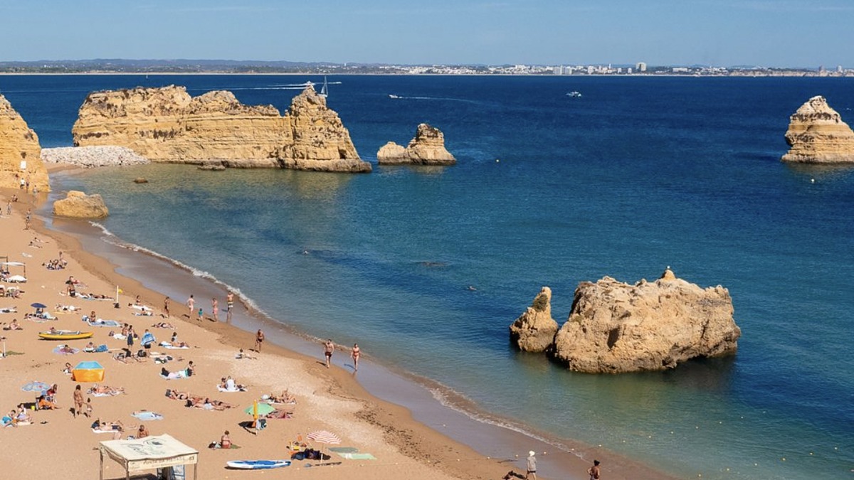 Praia da Dona Ana near Lagos, a golden-sand beach framed by sandstone cliffs and sea stacks, Algarve
