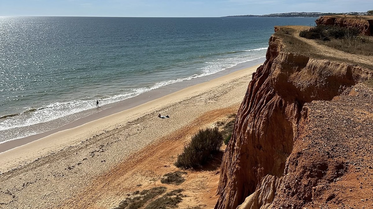The eroded red and orange clay cliffs above the long sandy stretch of Praia da Falesia, Algarve
