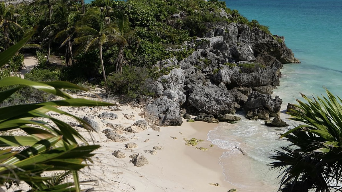 The Tulum ruins on the cliff above the turquoise Caribbean with the beach below, Riviera Maya