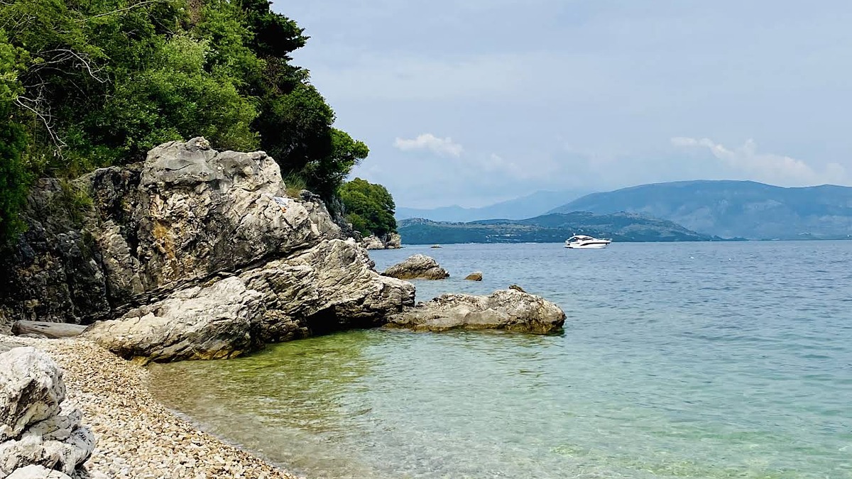 Agni Beach on Corfu's northeast coast, a small pebble cove with three tavernas lining the protected bay