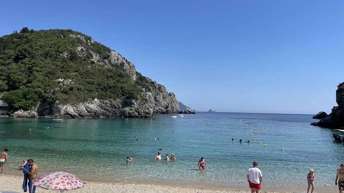 The turquoise cove at Paleokastritsa, Corfu, framed by steep green headlands