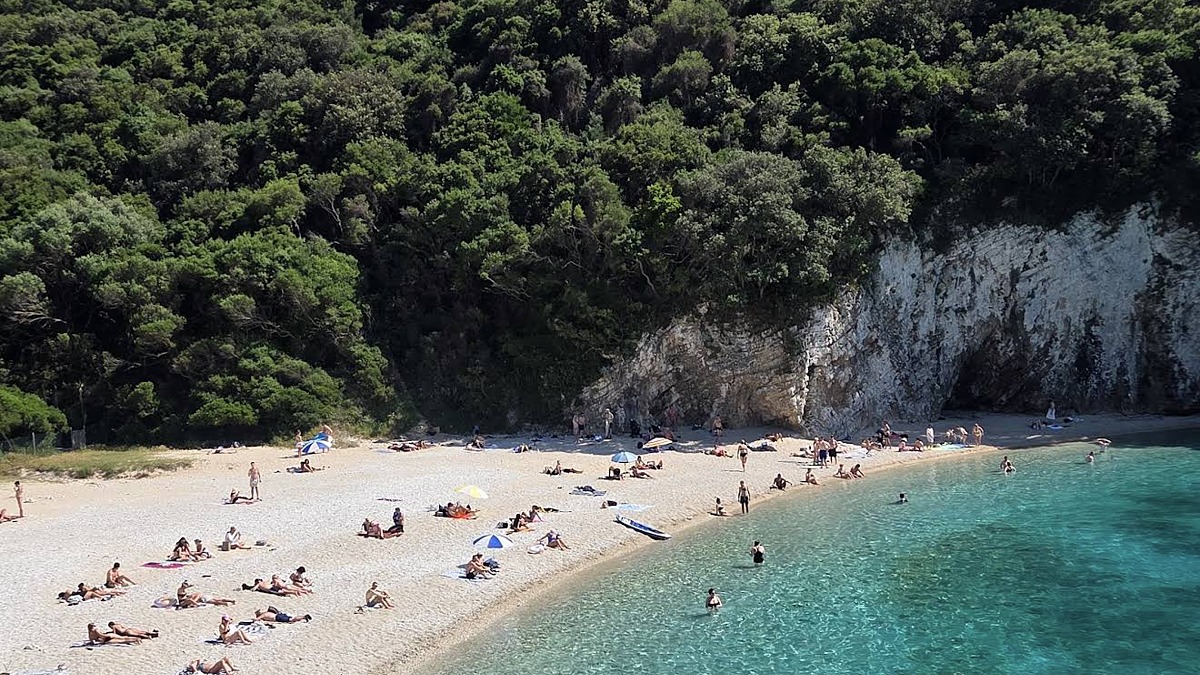 Rovinia Beach near Liapades on Corfu, a hidden pebble cove with clear deep water framed by cliffs and forest