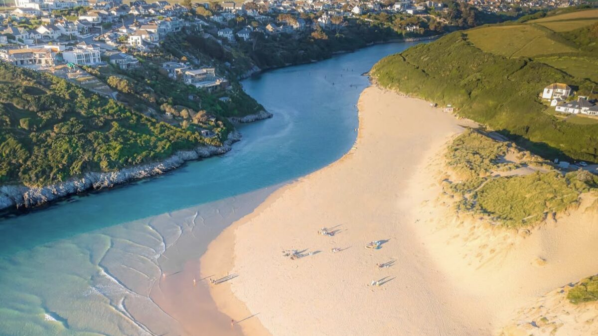 Crantock Beach white sand with grassy dunes and the Gannel estuary river running across the beach