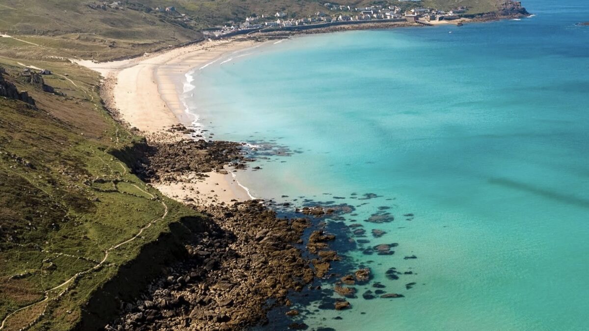 Sennen Cove and Whitesand Bay, a sweep of golden sand and turquoise water near Land's End with the village at the far end
