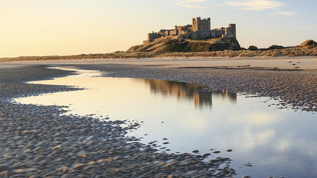 Bamburgh Beach in Northumberland, a wide golden sweep of sand below Bamburgh Castle