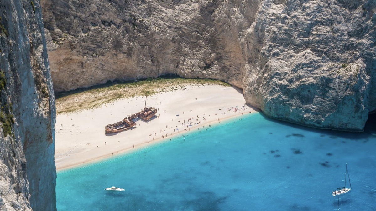 The shipwreck on white sand beneath towering cliffs at Navagio Beach, Zakynthos