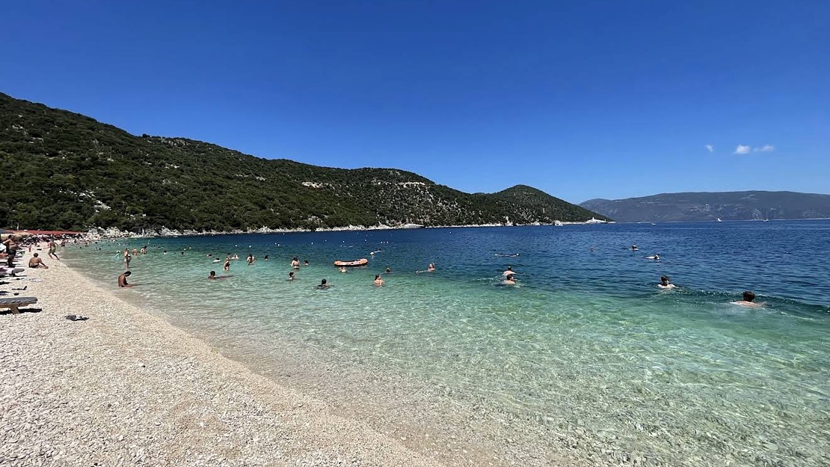 Antisamos Beach near Sami with a long pebble strip and green hills rising behind the calm protected bay