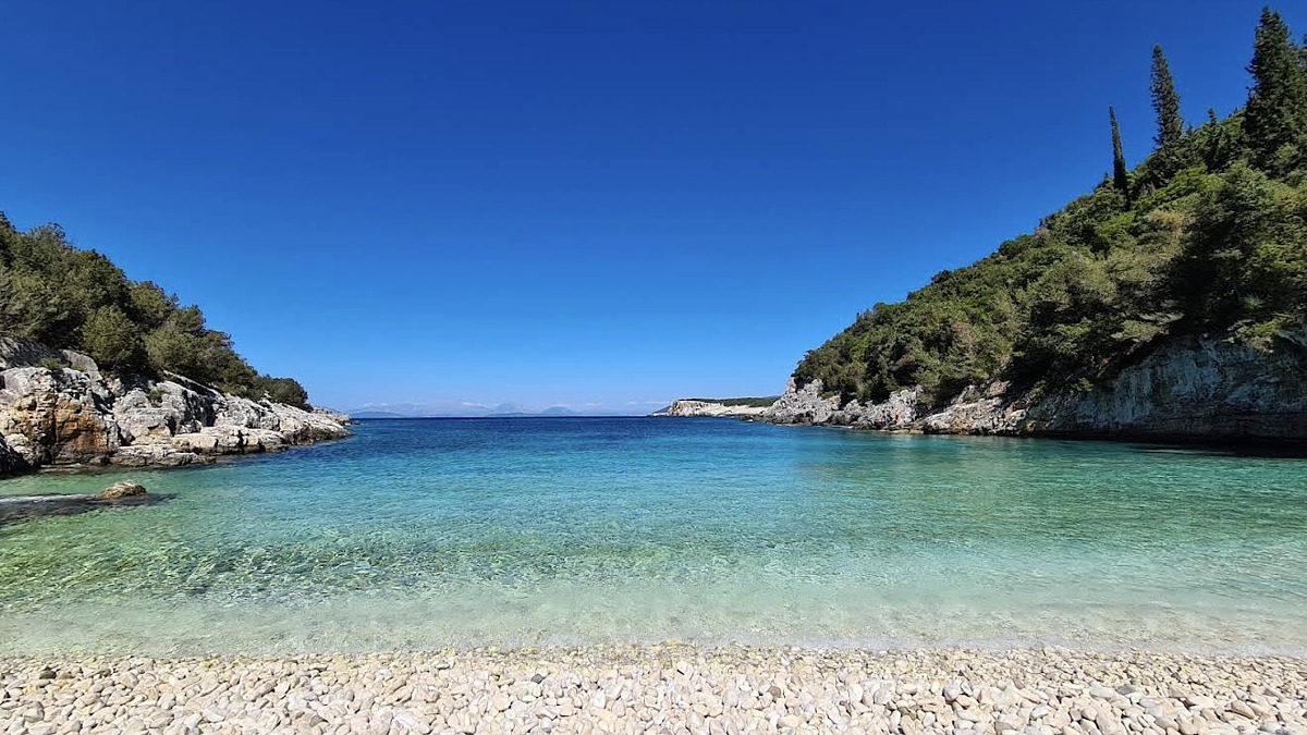 Dafnoudi Beach, a secluded white-pebble cove reached by a shaded forest path near Fiskardo