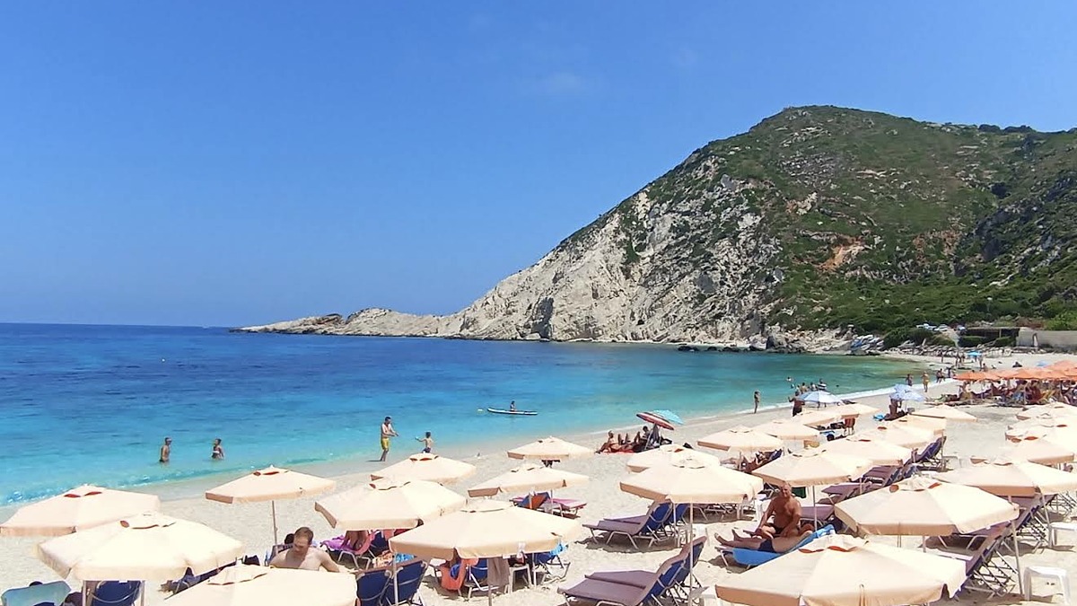 Petani Beach on the west coast of Kefalonia with white pebbles and deep turquoise water below dramatic cliffs