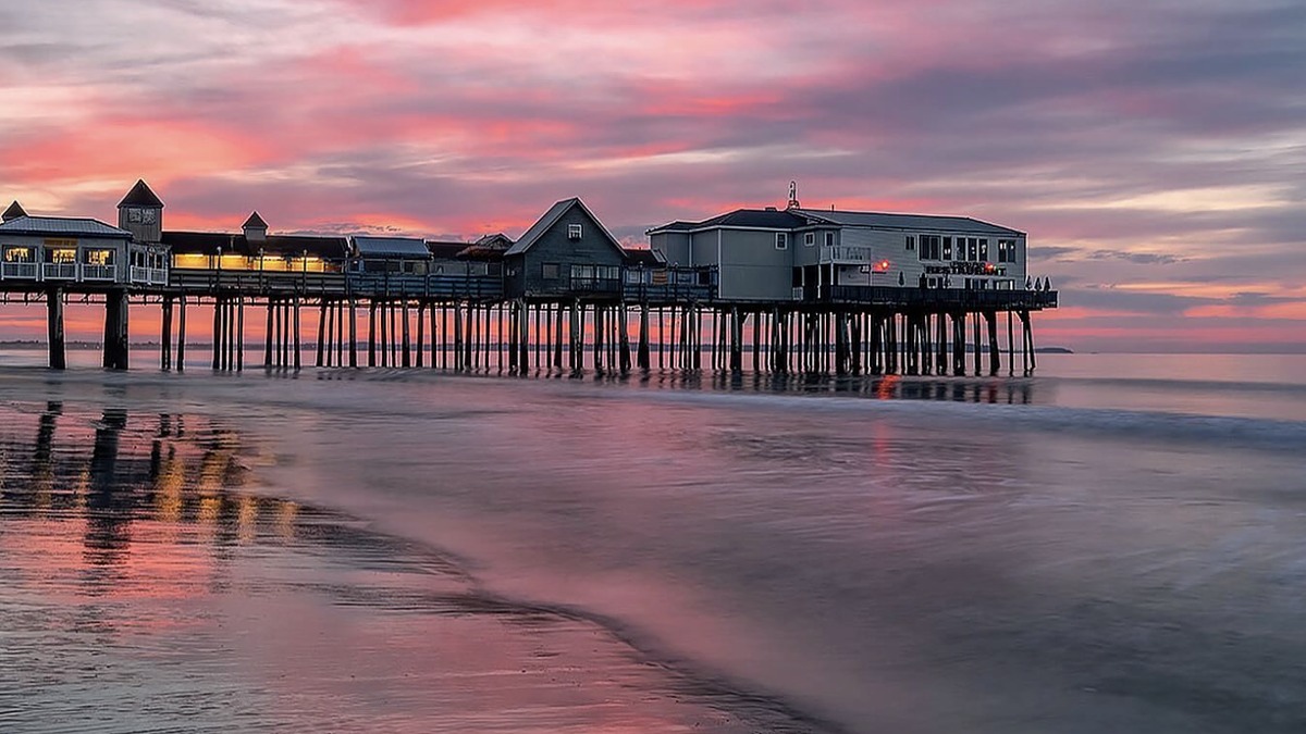 Old Orchard Beach pier with the amusement park Ferris wheel and a wide stretch of sand