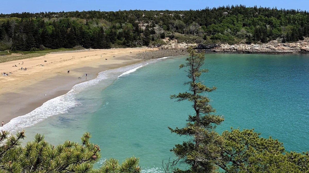 Sand Beach Acadia National Park with pink-tinged sand crescent enclosed by dark granite cliffs