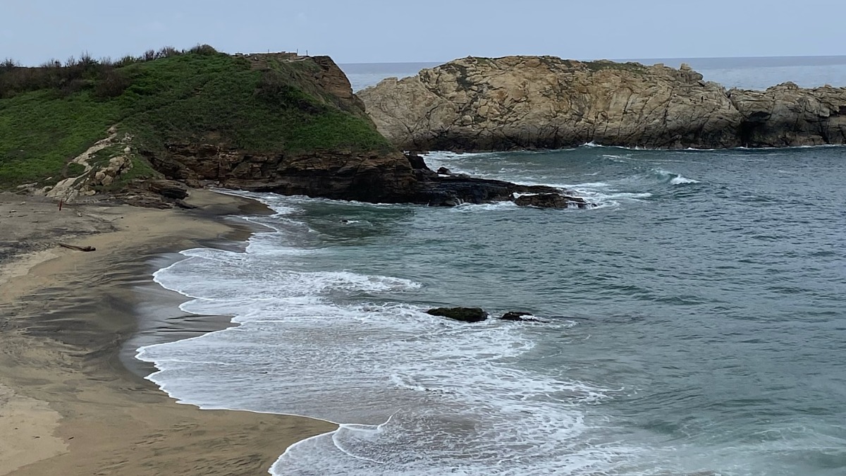 Mazunte Beach at sunset with sea turtle nesting sands and Punta Cometa behind