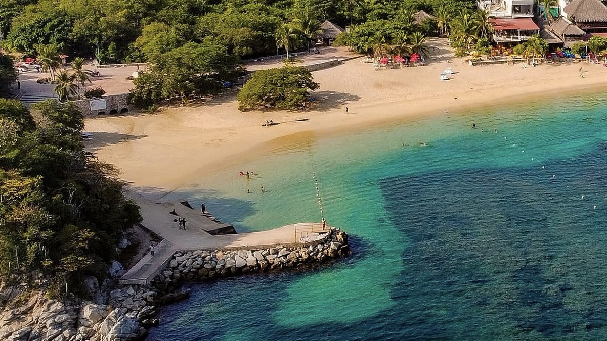Playa La Entrega in Bahías de Huatulco with calm water and palapa restaurants