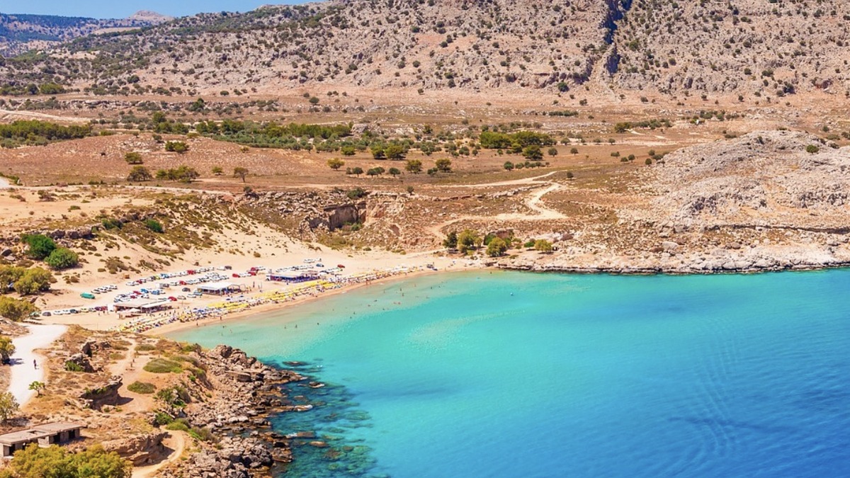 Agathi Beach near Charaki on Rhodes, a small golden sandy bay with shallow water below Feraklos castle