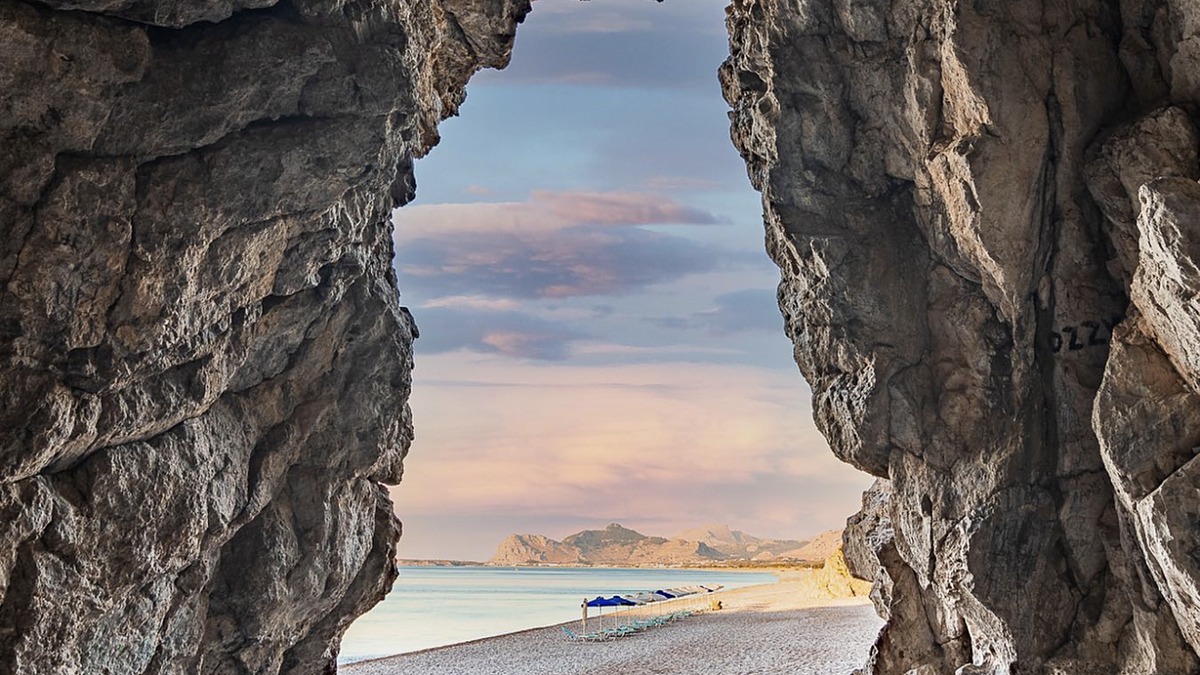 Traganou Beach south of Faliraki, a quiet sandy-pebble bay framed by cliffs on the east coast of Rhodes
