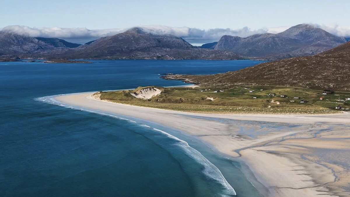 Aerial view of Seilebost beach, the crescent of pale sand and the tidal estuary looking across toward Luskentyre with the Harris hills behind