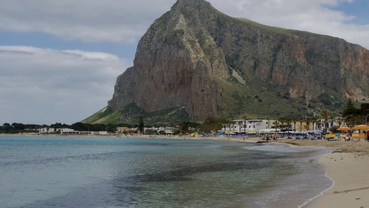 San Vito lo Capo in western Sicily, a wide curve of pale sand and shallow turquoise water below Monte Monaco