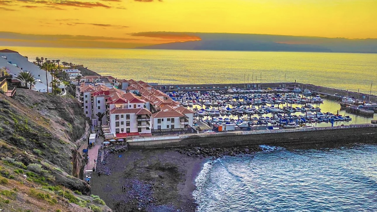 The marina and dark-sand beach below the cliffs at Los Gigantes on the west coast of Tenerife at sunset