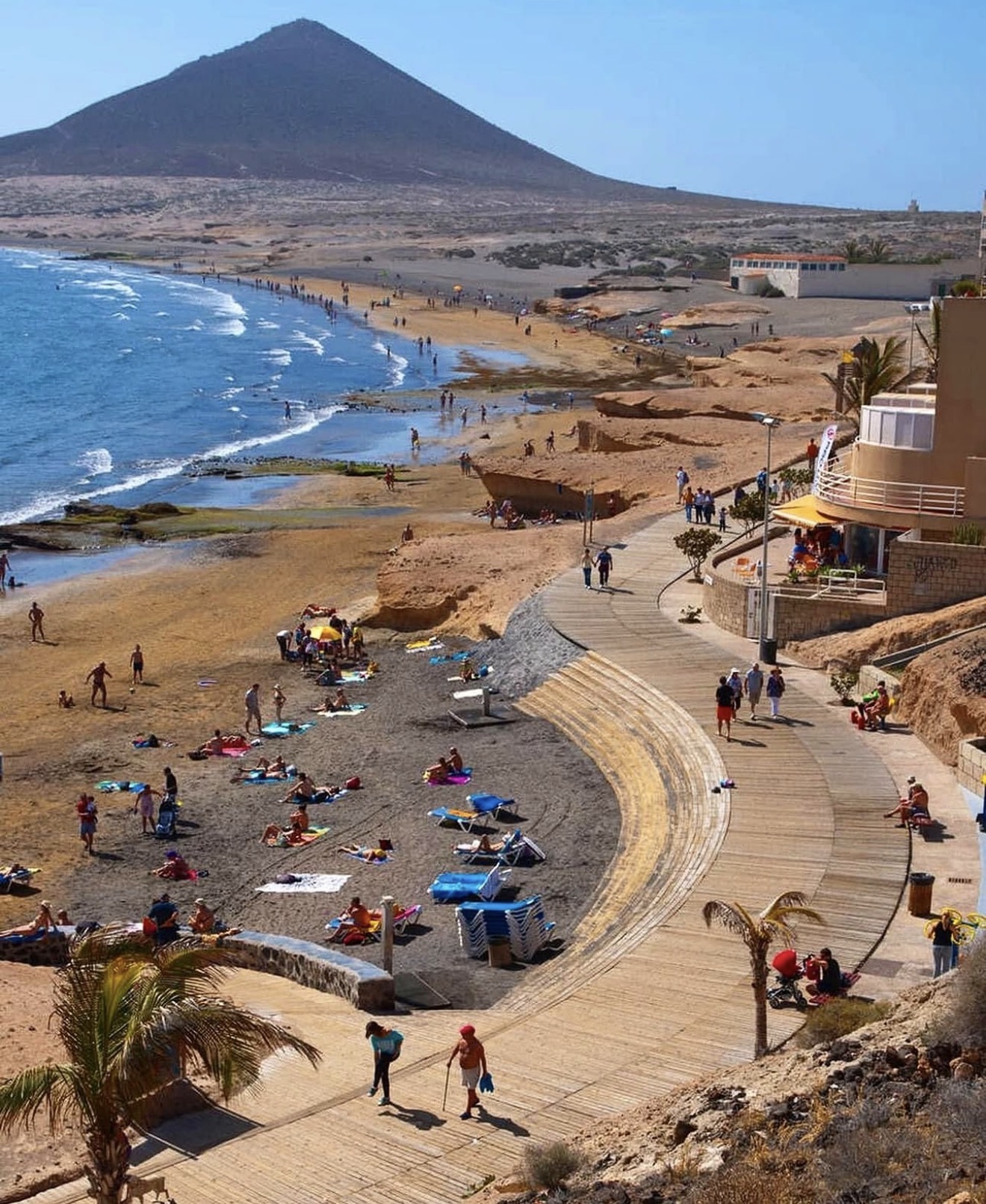 Kitesurfers on the water at El Medano beach with Montana Roja in the background