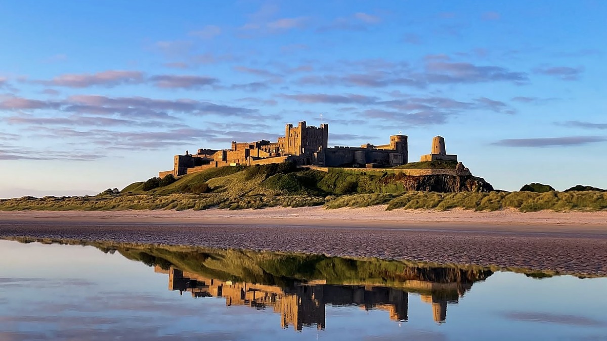 Bamburgh Beach in Northumberland with the medieval castle on the hill behind the wide empty sand